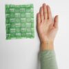 Moxa heat pack beside a hand for size comparison.